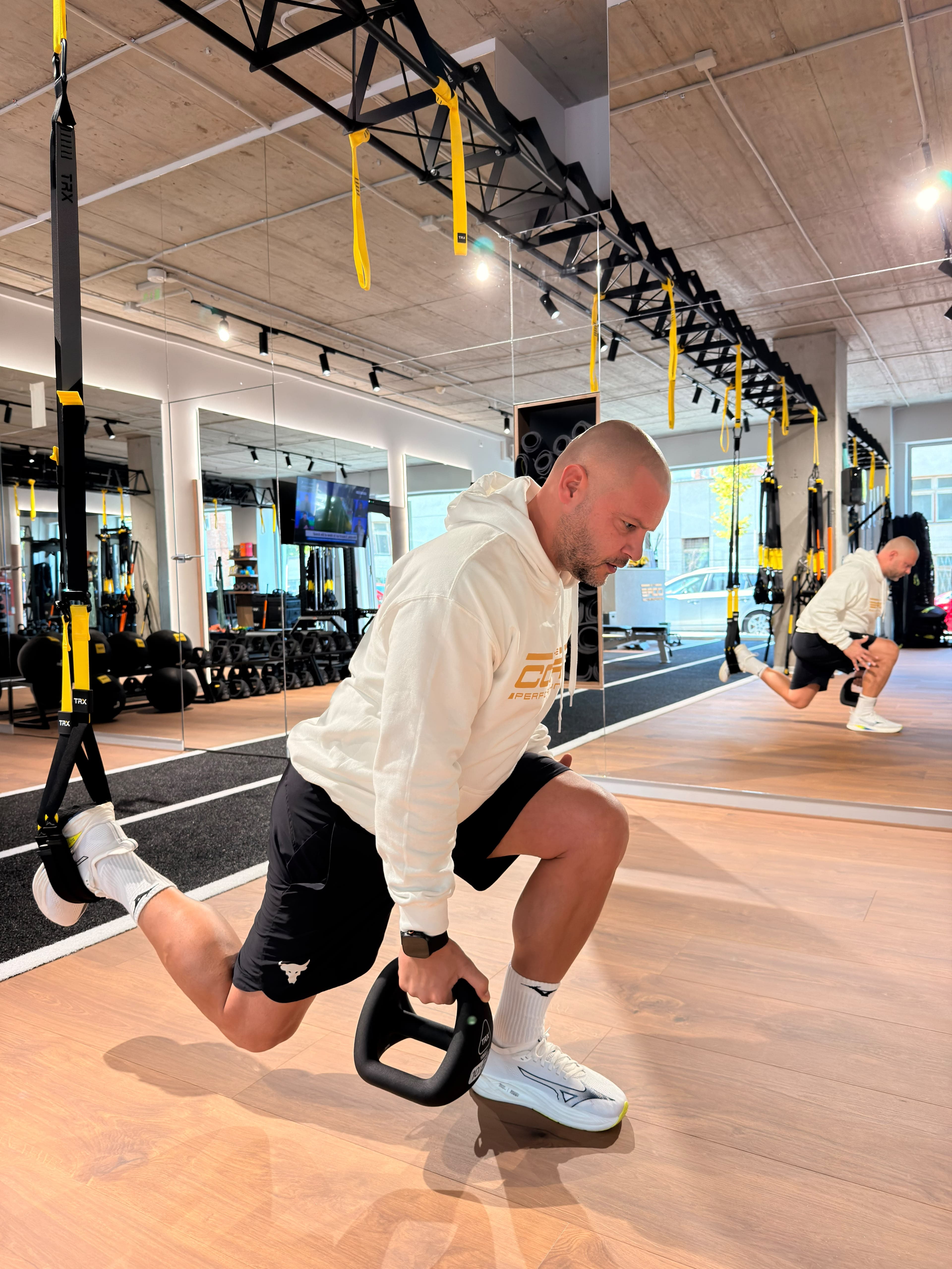 Trainer performing a TRX lunge with a YBell in The Core Performance studio
