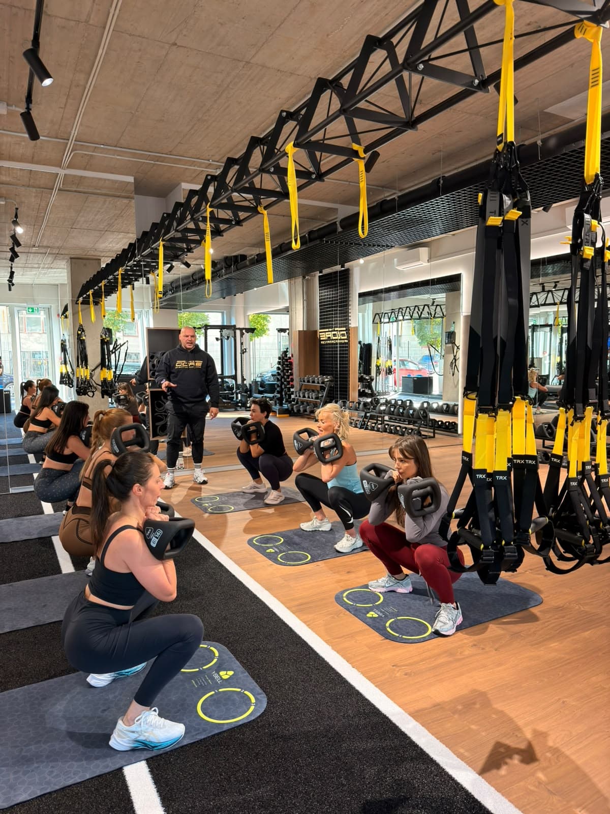 Group class doing goblet squats with Ybells